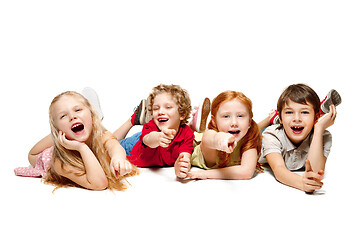 Image showing Close-up of happy children lying on floor in studio and looking up, isolated on white background