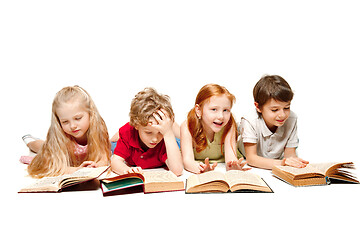 Image showing The kids boy and girls laying with books isolated on white