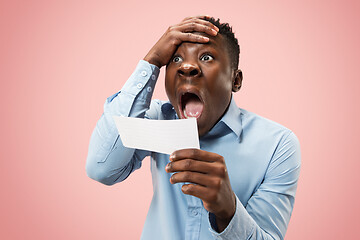 Image showing Young boy with a surprised expression bet slip on pink background