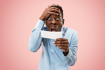 Image showing Young boy with a surprised expression bet slip on pink background