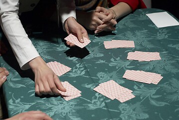 Image showing Female croupier shuffling cards on gambling table