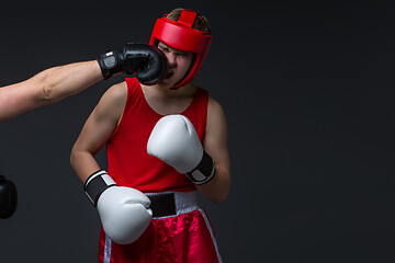 Image showing young boxer is being punched