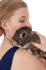 Image showing Young woman holding a rabbit on her shoulder