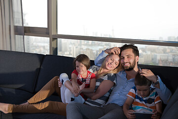 Image showing happy young couple spending time with kids at home