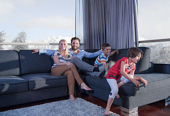 Image showing happy young couple spending time with kids at home