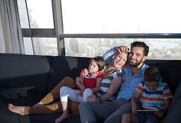 Image showing happy young couple spending time with kids at home