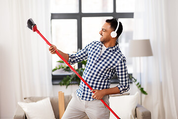 Image showing man with broom cleaning and having fun at home