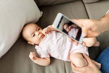 Image showing father with smartphone taking picture baby at home