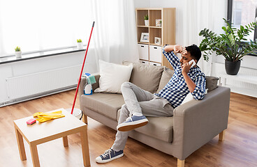 Image showing man calling on smartphone after cleaning home