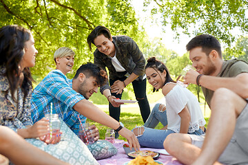 Image showing friends with drinks and food at picnic in park