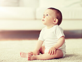 Image showing happy baby boy or girl sitting on floor at home