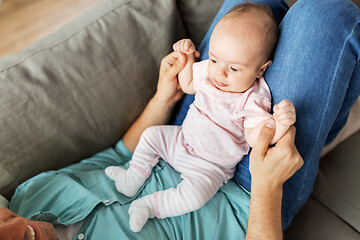 Image showing middle aged father with baby lying on sofa at home