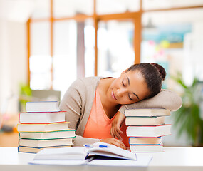 Image showing tired african female student sleeping on books