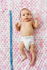 Image showing baby girl lying with measure tape on blanket