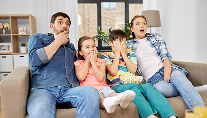 Image showing scared family with popcorn watching horror on tv