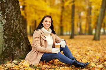 Image showing woman drinking takeaway coffee in autumn park