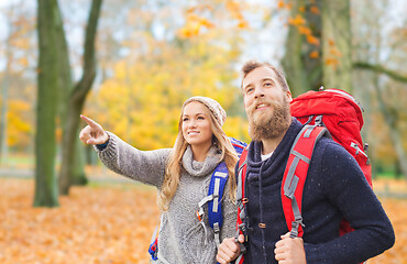 Image showing smiling couple with backpacks hiking in autumn