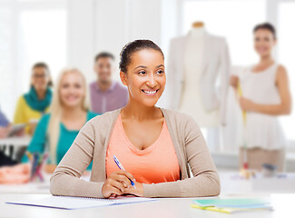 Image showing fashion designer with notebook over studio