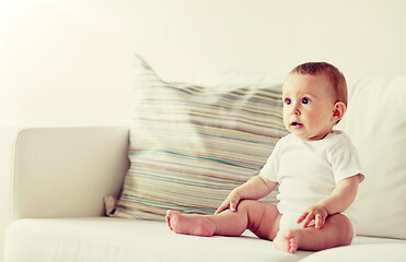 Image showing happy baby boy or girl sitting on sofa at home