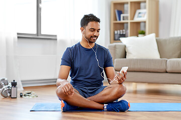 Image showing indian man with smartphone on exercise mat at home