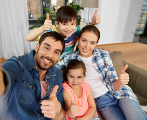 Image showing family taking selfie and showing thumbs up at home