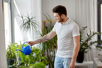 Image showing man watering houseplants at home