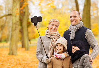 Image showing happy family with smartphone and monopod in park