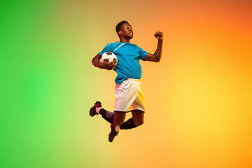 Image showing Male soccer, football player training in action isolated on gradient studio background in neon light