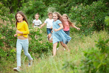 Image showing Kids, children running on green meadow, forest. Childhood and summertime