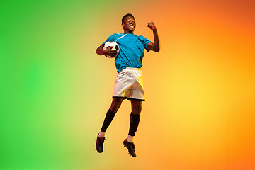 Image showing Male soccer, football player training in action isolated on gradient studio background in neon light