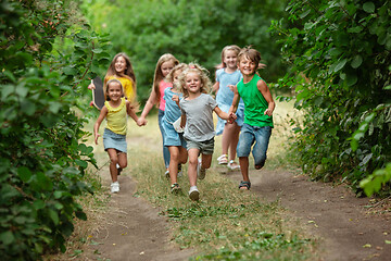 Image showing Kids, children running on green meadow, forest. Childhood and summertime