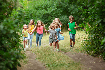 Image showing Kids, children running on green meadow, forest. Childhood and summertime