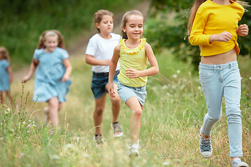 Image showing Kids, children running on green meadow, forest. Childhood and summertime