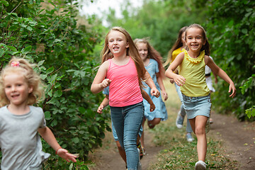 Image showing Kids, children running on green meadow, forest. Childhood and summertime