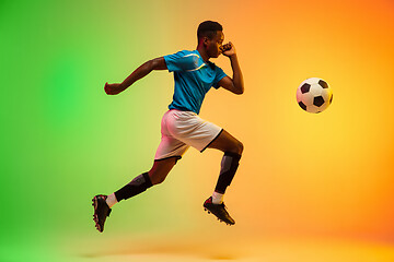 Image showing Male soccer, football player training in action isolated on gradient studio background in neon light