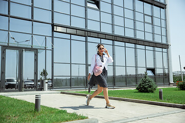 Image showing Young woman walking against glass\' wall in airport, traveler with small baggage, influencer\'s lifestyle