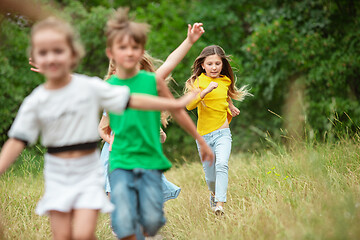 Image showing Kids, children running on green meadow, forest. Childhood and summertime