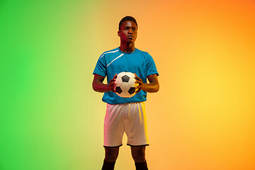 Image showing Male soccer, football player training in action isolated on gradient studio background in neon light