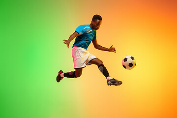 Image showing Male soccer, football player training in action isolated on gradient studio background in neon light