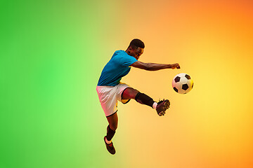 Image showing Male soccer, football player training in action isolated on gradient studio background in neon light