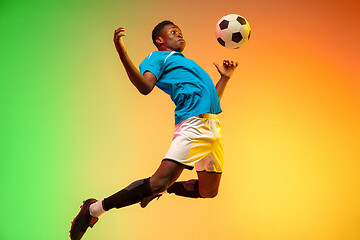 Image showing Male soccer, football player training in action isolated on gradient studio background in neon light