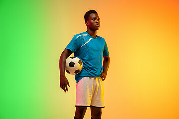 Image showing Male soccer, football player training in action isolated on gradient studio background in neon light