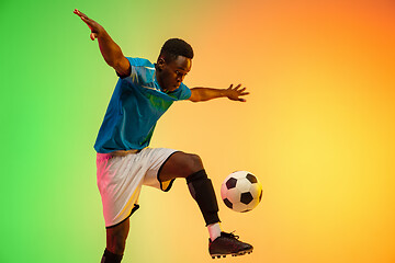 Image showing Male soccer, football player training in action isolated on gradient studio background in neon light