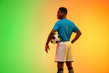 Image showing Male soccer, football player training in action isolated on gradient studio background in neon light