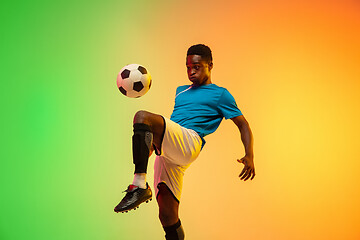 Image showing Male soccer, football player training in action isolated on gradient studio background in neon light