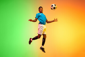 Image showing Male soccer, football player training in action isolated on gradient studio background in neon light