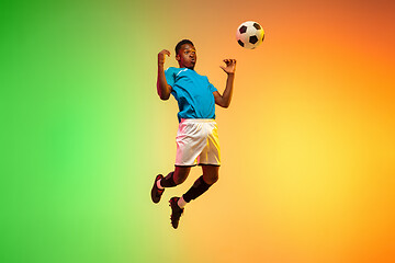 Image showing Male soccer, football player training in action isolated on gradient studio background in neon light