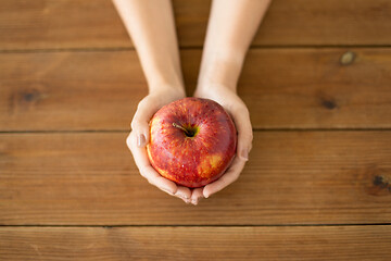 Image showing close up of hands holding ripe red apple