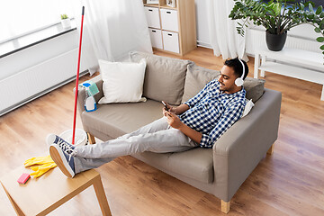 Image showing indian man in headphones after cleaning home