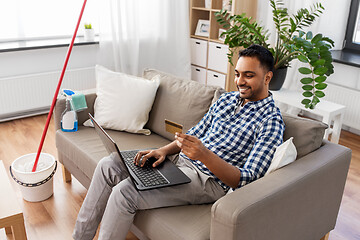 Image showing man with laptop shopping online after cleaning